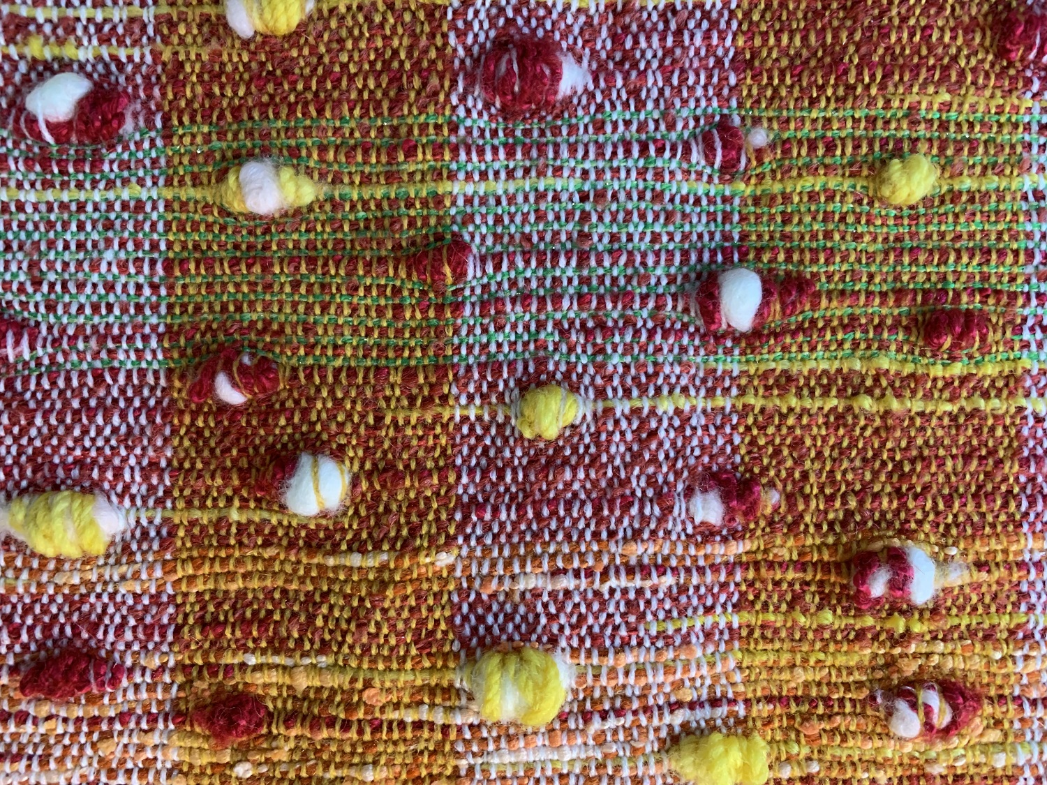 紗線纏繞羊毛，形成顆粒狀後，以不均勻的形式夾入布面中，呈現出豐富的顆粒感畫面。